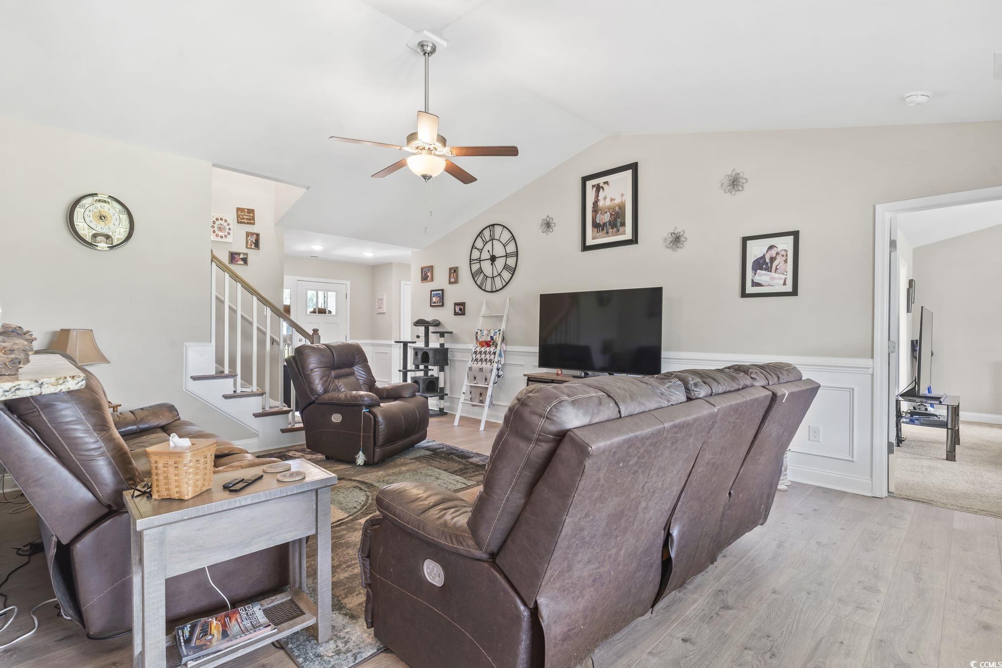 1170 Daisy Road Loris, SC 29569 - Photo 8 of 35 Living area with ceiling fan, light wood-type flooring, wainscoting, stairs, and vaulted ceiling