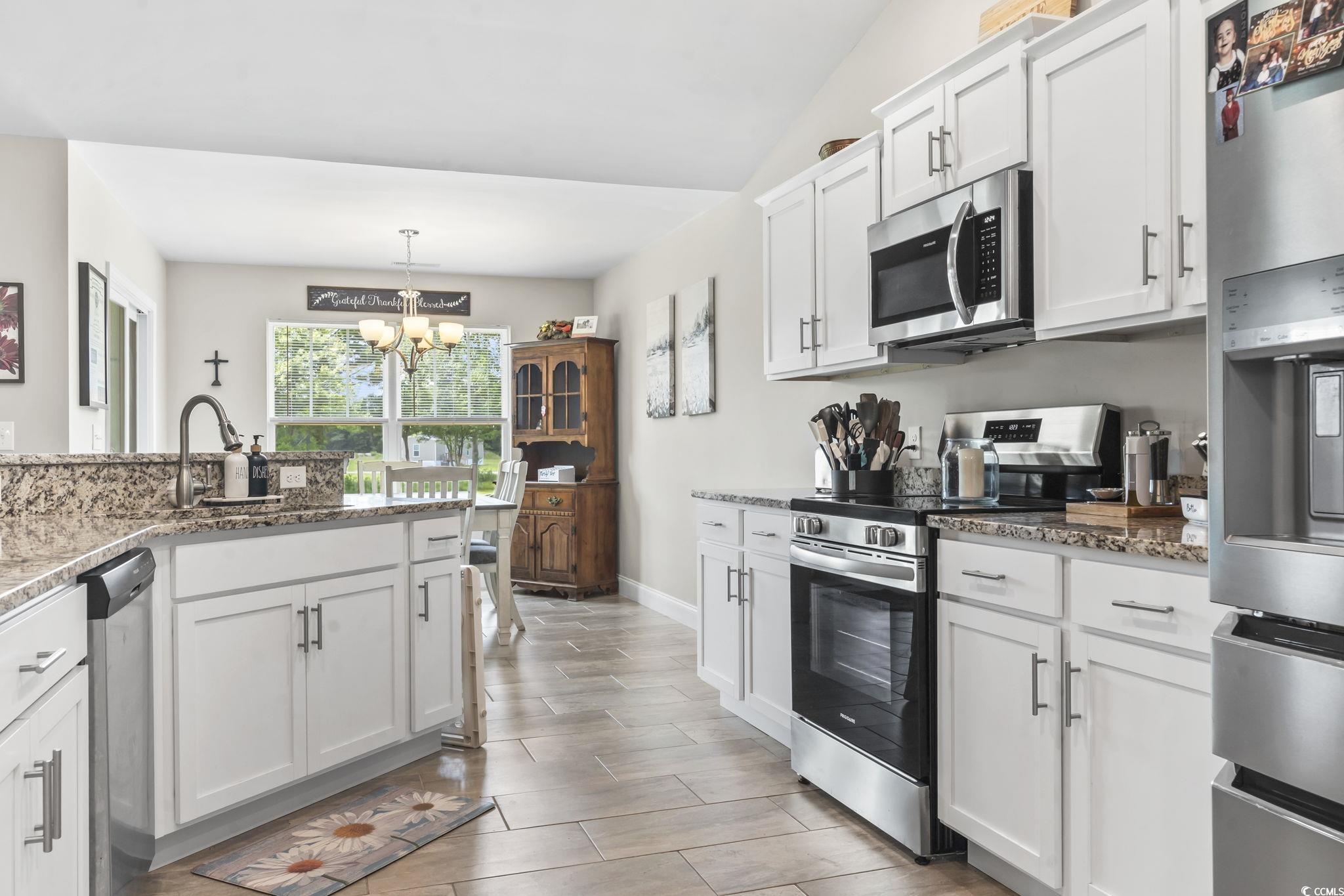 1170 Daisy Road Loris, SC 29569 - Photo 10 of 35 Kitchen featuring stainless steel appliances, a chandelier, white cabinetry, light stone counters, and hanging light fixtures