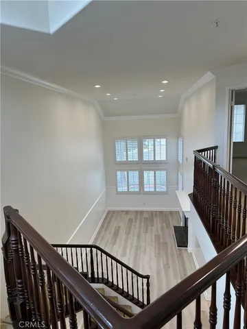 a view of a hallway with wooden floor and staircase