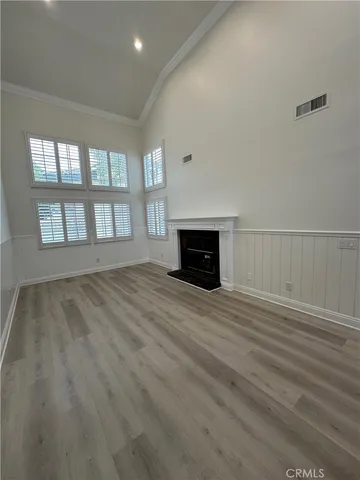 a view of empty room with wooden floor and fireplace