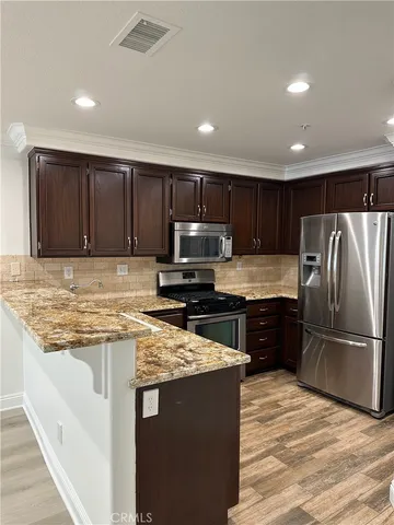 a kitchen with granite countertop wooden cabinets and stainless steel appliances
