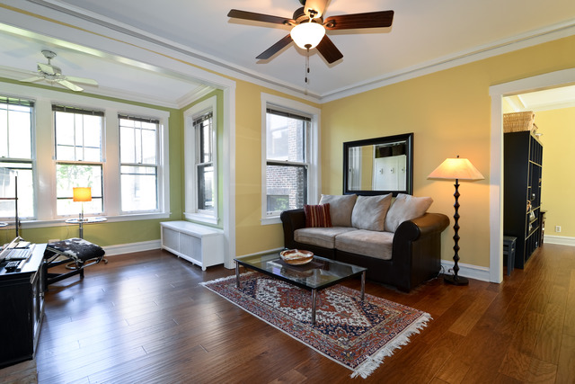 751 West Brompton Avenue, Unit 2E Chicago, IL 60657 - Photo 2 of 10 a living room with couches a coffee table and a chandelier with wooden floor