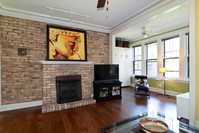 751 West Brompton Avenue, Unit 2E Chicago, IL 60657 - Photo 3 of 10 a living room with furniture flat screen tv and a fireplace