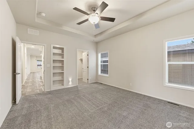 an empty room with closet and windows