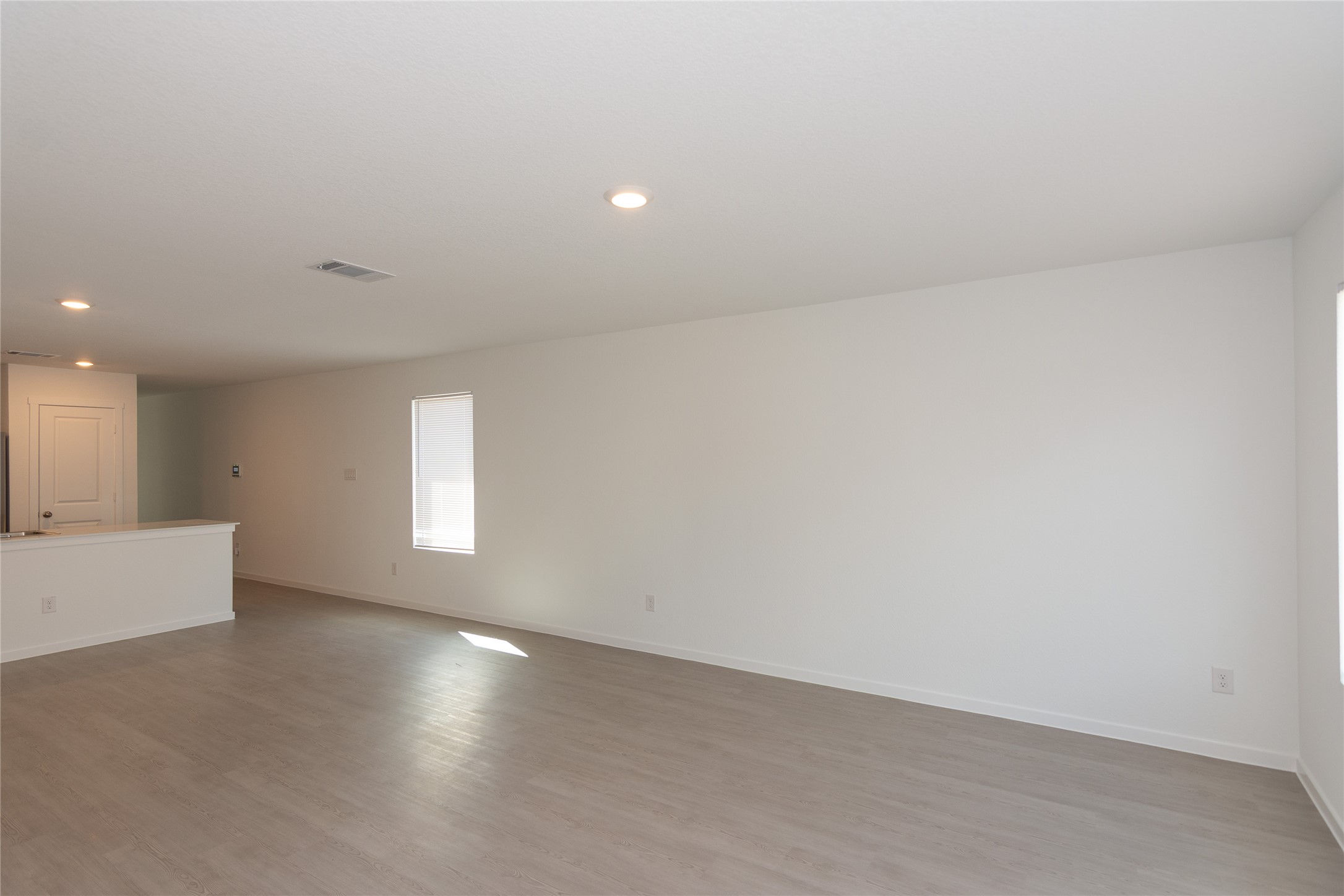 149 Star Packer Lane Jarrell, TX 76537 - Photo 6 of 30 Recessed lighting illuminates an open living area with light-toned flooring, ready for your personalized touch.