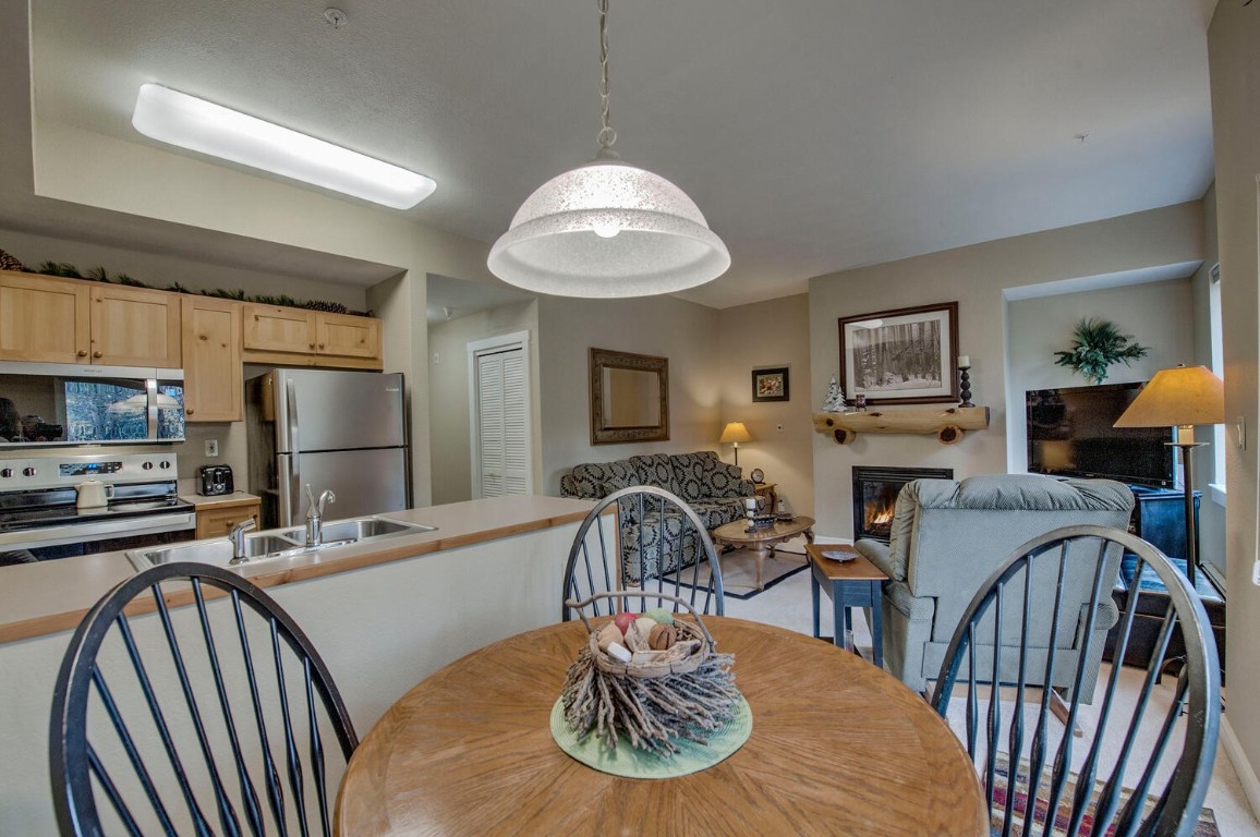 97 Lake Ridge Circle, Unit 1854 Keystone, CO 80435 - Photo 14 of 38 a kitchen with stainless steel appliances granite countertop a table chairs and a refrigerator