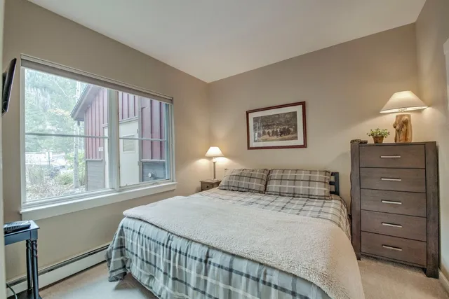 a bedroom with a bed a lamp and a window