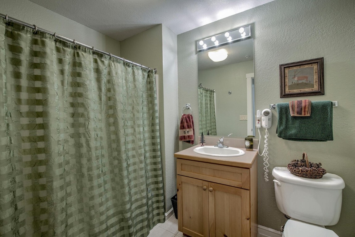 97 Lake Ridge Circle, Unit 1854 Keystone, CO 80435 - Photo 21 of 38 a bathroom with a sink toilet and mirror