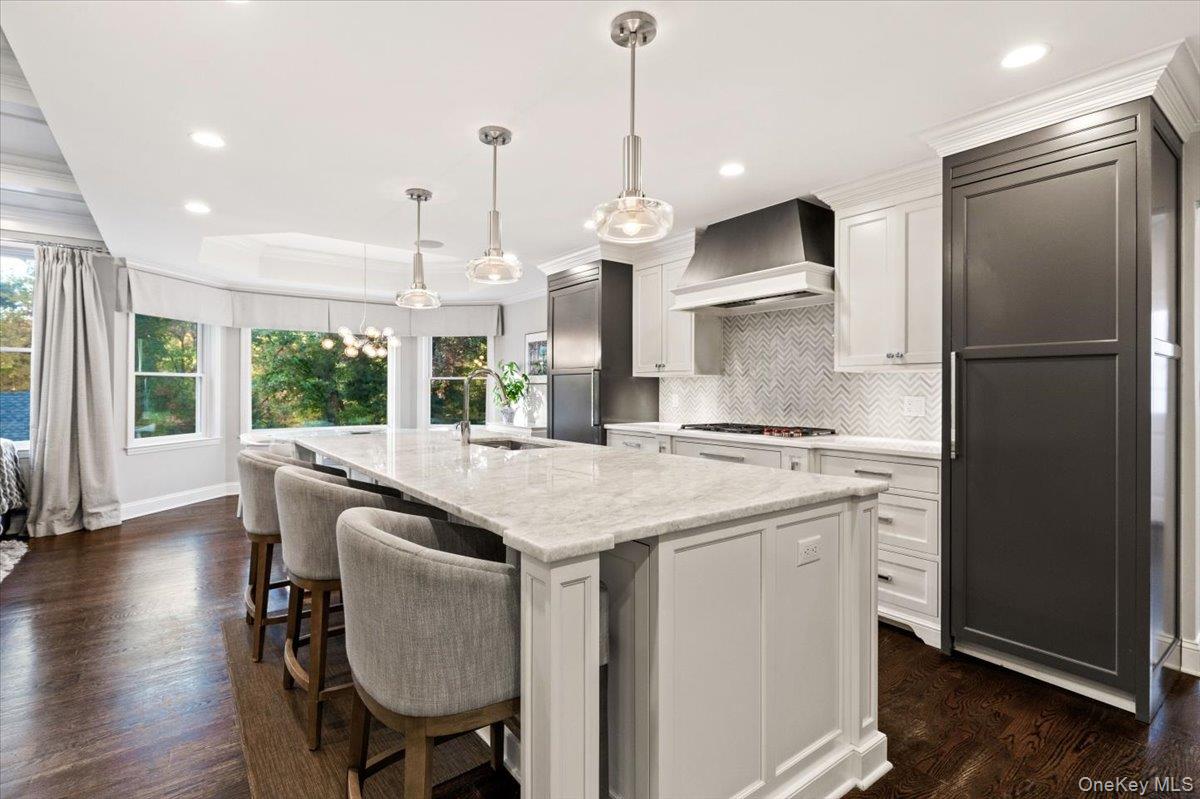 6 Valley Place Harrison, NY 10528 - Photo 8 of 37 a kitchen with stainless steel appliances granite countertop a refrigerator a sink dishwasher a stove and a dining table with wooden floor