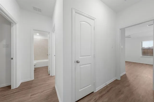 a view of a hallway with wooden floor