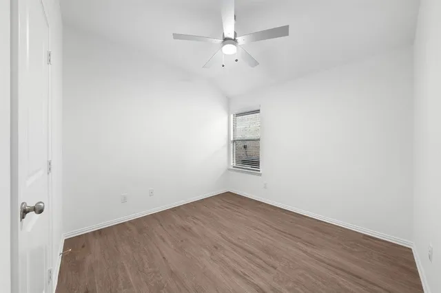 a view of a room with wooden floor and a ceiling fan