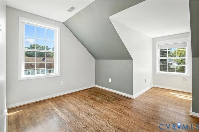 a view of an empty room with wooden floor