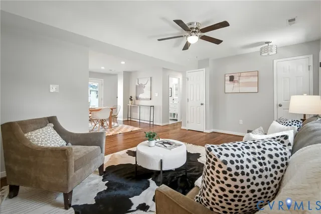 a living room with furniture and a view of kitchen