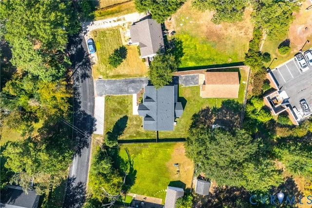 an aerial view of residential houses with outdoor space and trees