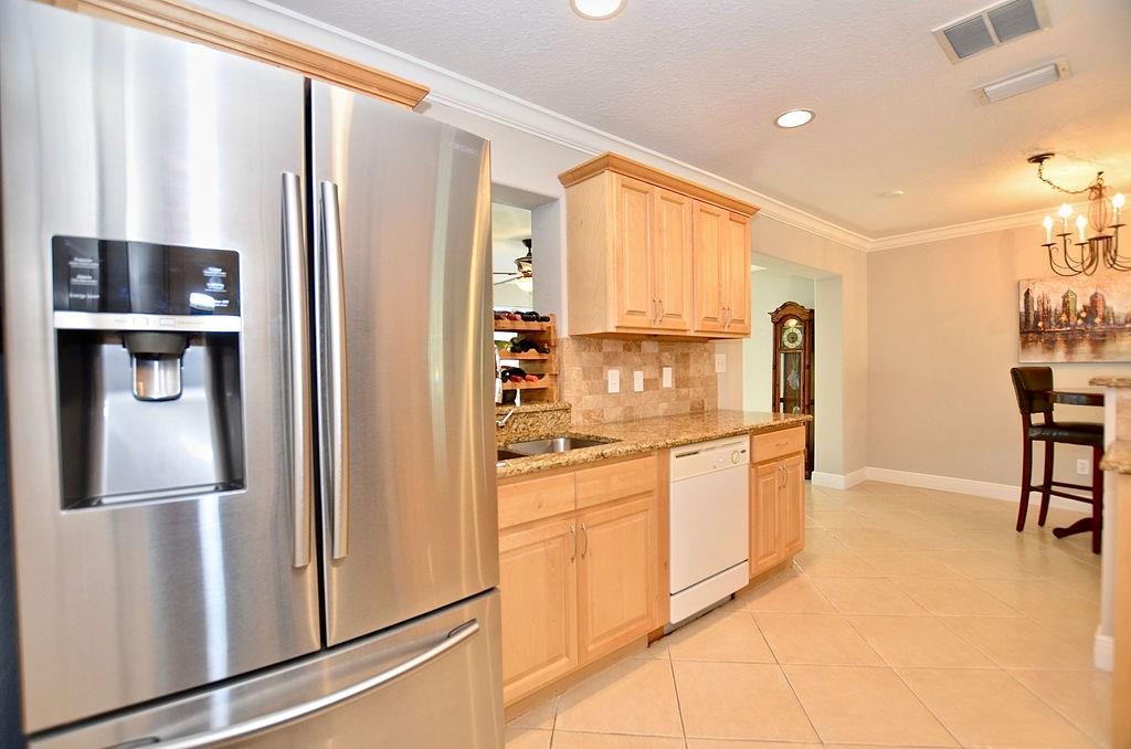 459 Southwest Byron Street Port St. Lucie, FL 34983 - Photo 16 of 51 a kitchen with stainless steel appliances granite countertop a refrigerator and a stove