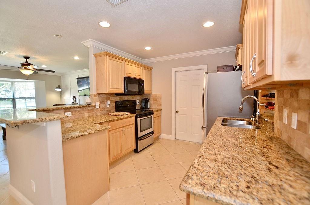 459 Southwest Byron Street Port St. Lucie, FL 34983 - Photo 17 of 51 a kitchen with stainless steel appliances granite countertop a sink stove and refrigerator