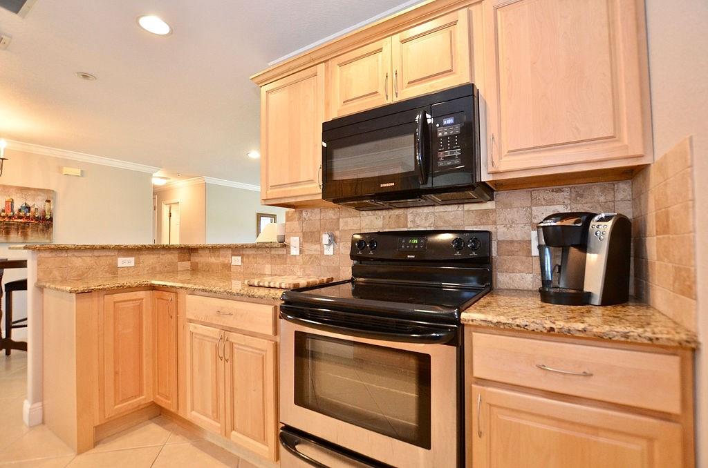 459 Southwest Byron Street Port St. Lucie, FL 34983 - Photo 18 of 51 a kitchen with stainless steel appliances granite countertop a stove microwave and sink