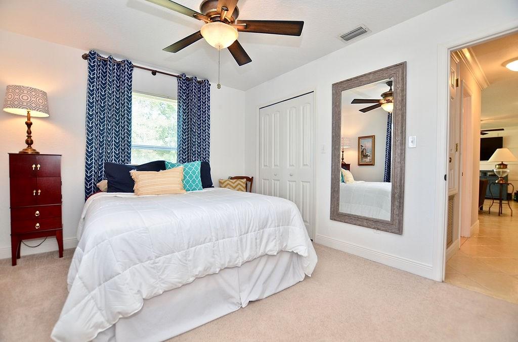 459 Southwest Byron Street Port St. Lucie, FL 34983 - Photo 26 of 51 a bedroom with a large bed and a chandelier