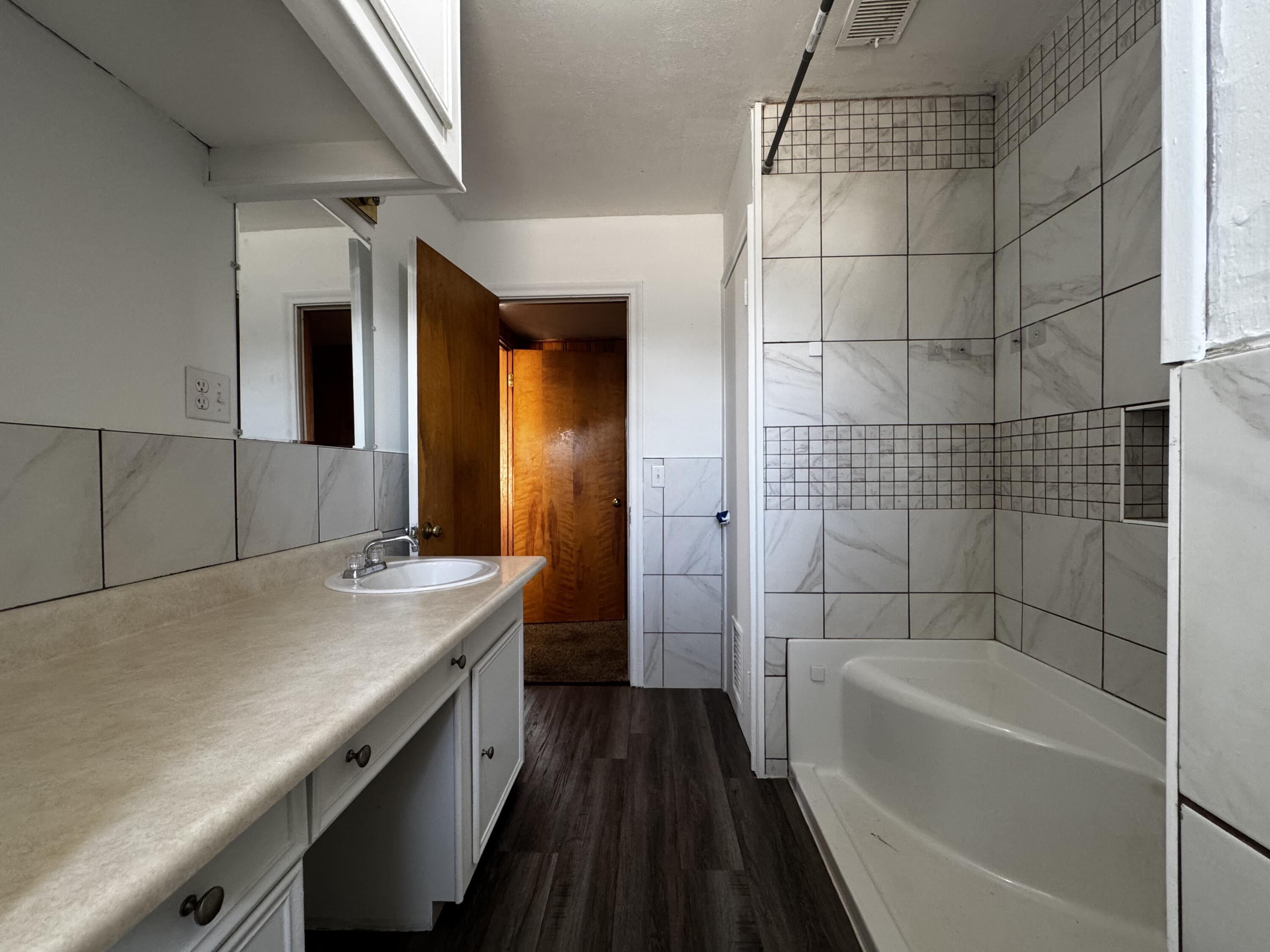 110 North 15th Street Lamesa, TX 79331 - Photo 20 of 28 a bathroom with a granite countertop sink a toilet and shower