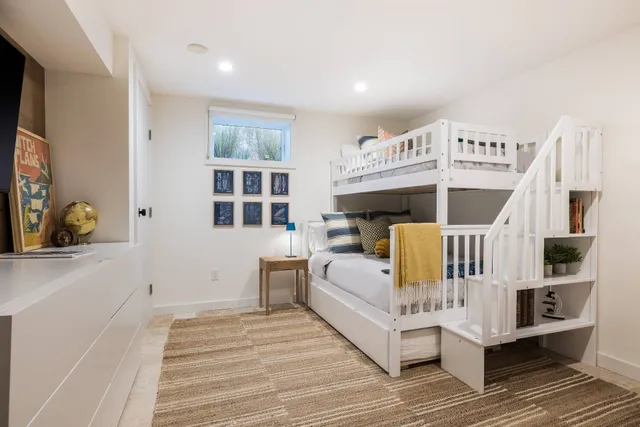 a view of a bedroom with a bed and wooden floor