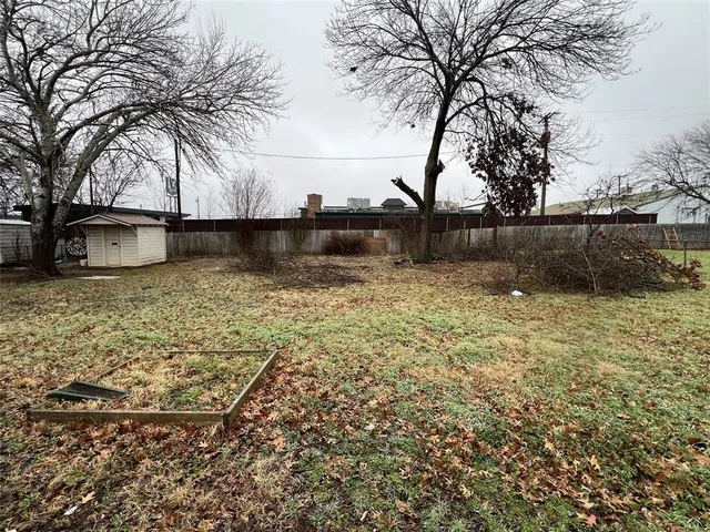 a view of a yard with large trees