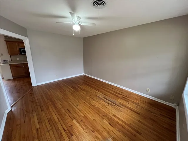 a view of empty room with wooden floor