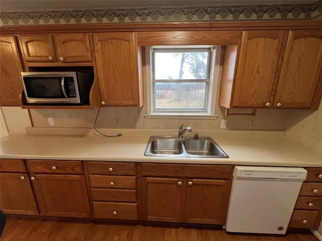a kitchen with sink a microwave and cabinets