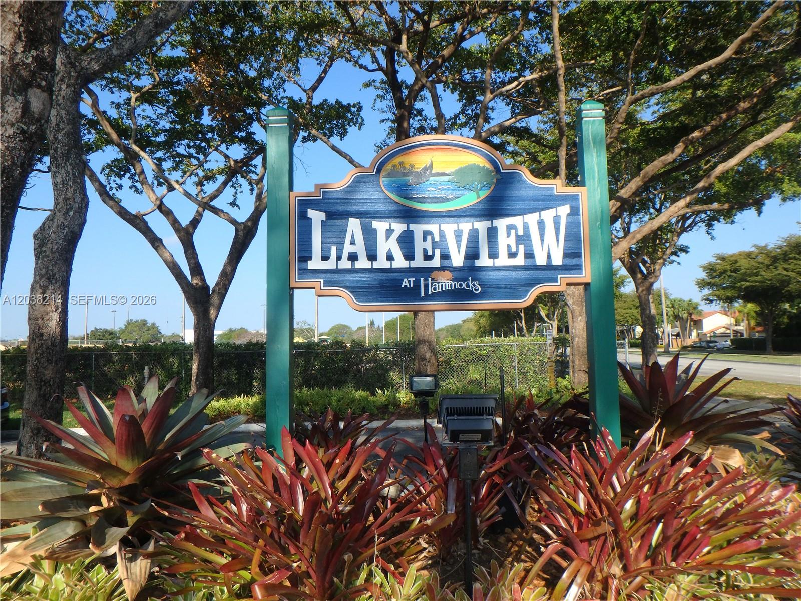 9727 Hammocks Boulevard, Unit 101D Miami, FL 33196 - Photo 1 of 12 a view of a sign board with large trees