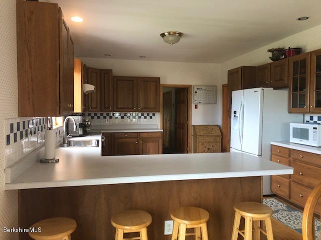 110 Hill Cemetery Road Windsor, MA 01270 - Photo 19 of 52 a kitchen with stainless steel appliances a dining table and chairs