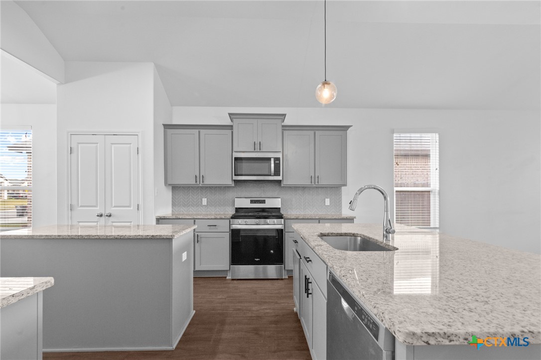 103 Dripping Spring Victoria, TX 77904 - Photo 5 of 27 a kitchen with kitchen island granite countertop a sink stainless steel appliances and white cabinets