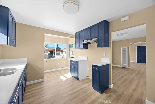 a kitchen with wooden floors and wooden cabinets