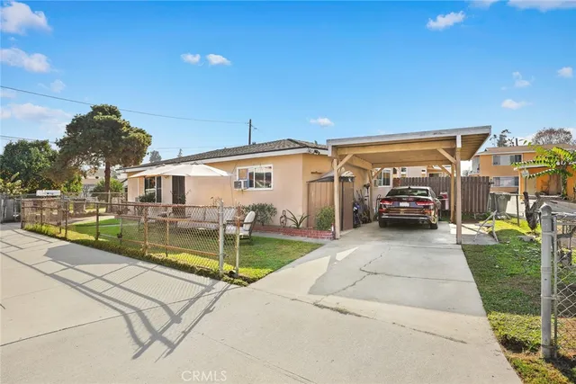 a view of a white house with swimming pool lawn chairs and a yard