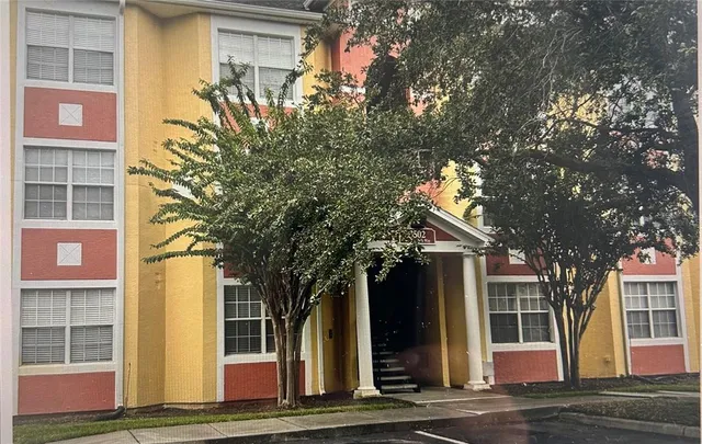 a front view of a house with a tree