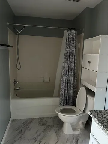 a bathroom with a toilet and a shower