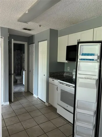 a kitchen with a refrigerator and a stove top oven