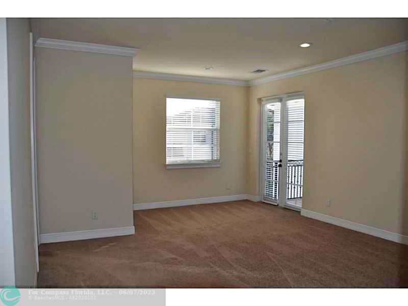 105 Via Floresta Drive Boca Raton, FL 33487 - Photo 11 of 26 a view of an empty room with wooden floor and a window