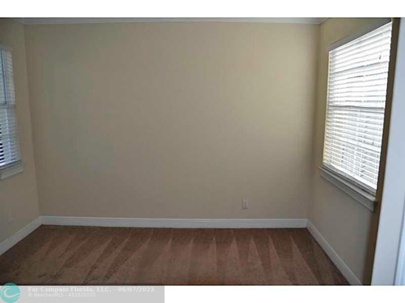 105 Via Floresta Drive Boca Raton, FL 33487 - Photo 18 of 26 a view of an empty room with wooden floor and a window
