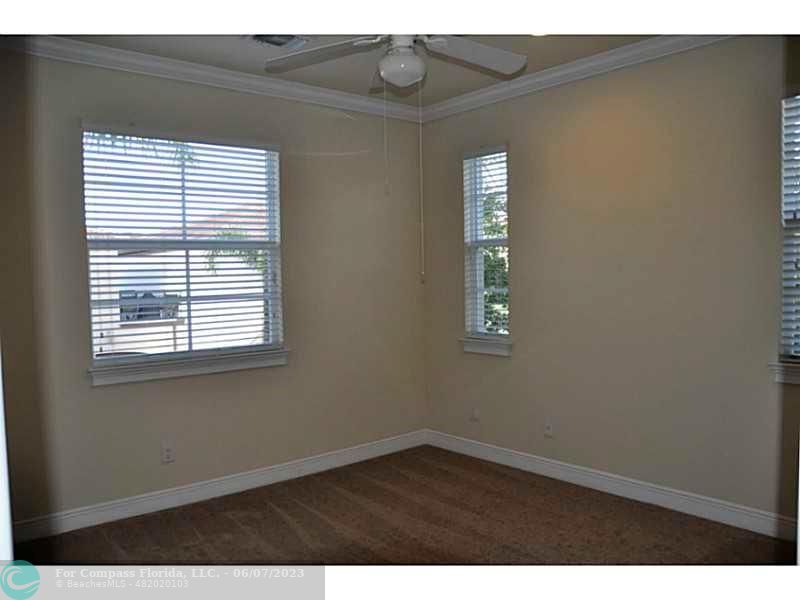 105 Via Floresta Drive Boca Raton, FL 33487 - Photo 19 of 26 a view of an empty room with wooden floor and a window