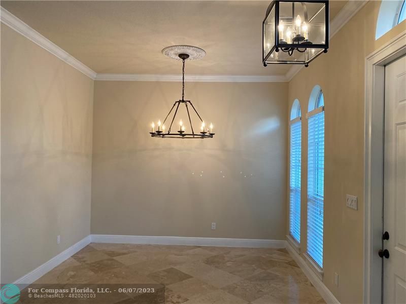 105 Via Floresta Drive Boca Raton, FL 33487 - Photo 7 of 26 a view of a room with a chandelier fan and wooden floor