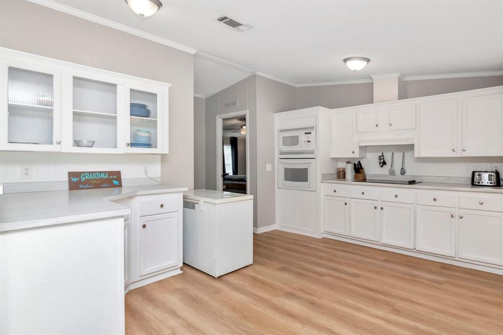 10404 Hawk Court Riverview, FL 33578 - Photo 14 of 38 a kitchen with stainless steel appliances white cabinets and wooden floors