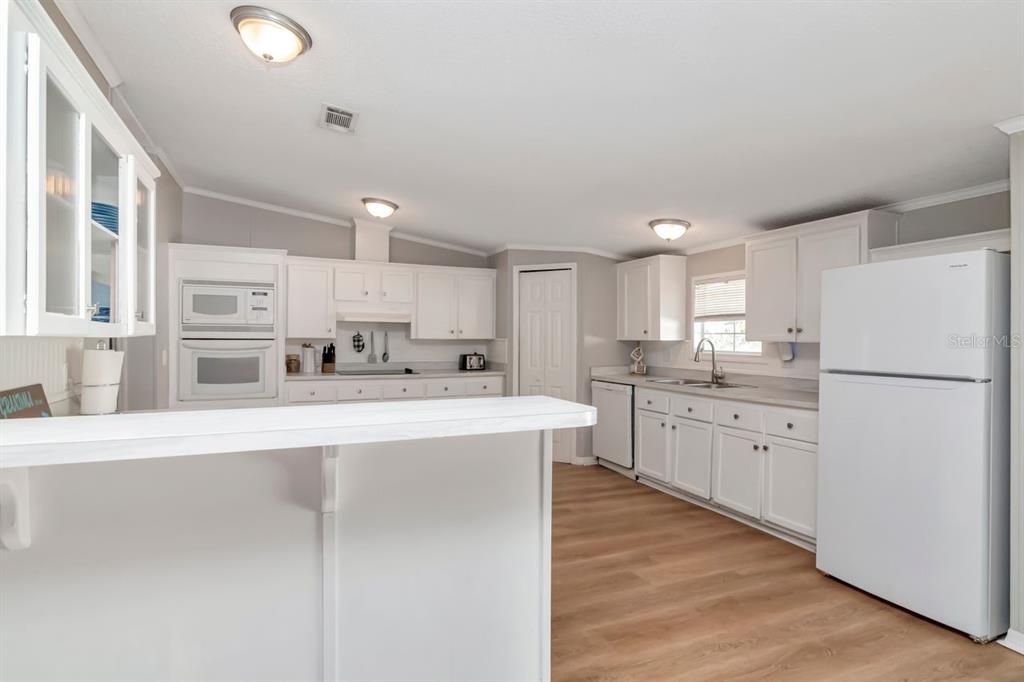 10404 Hawk Court Riverview, FL 33578 - Photo 16 of 38 a kitchen with white cabinets and white appliances