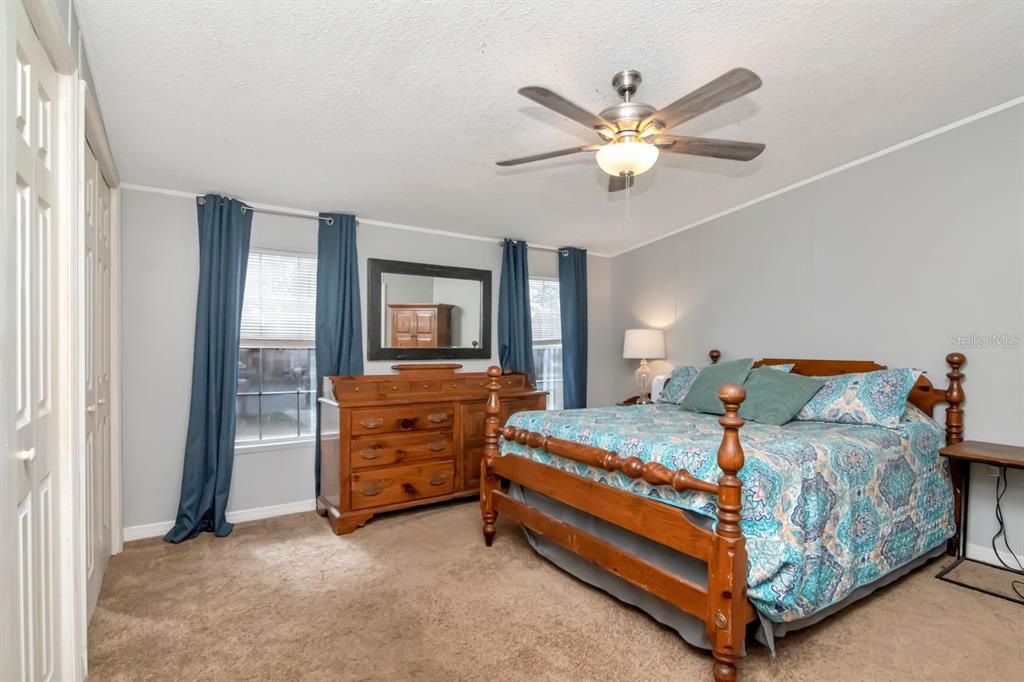 10404 Hawk Court Riverview, FL 33578 - Photo 18 of 38 a bedroom with a bed and a chandelier