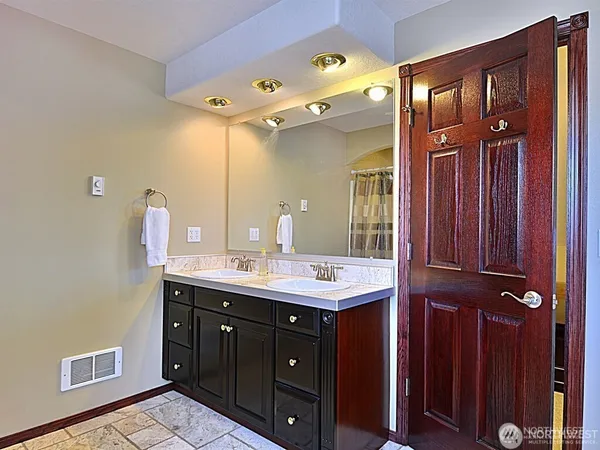 a bathroom with a double vanity sink and a mirror
