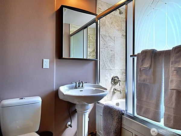 a bathroom with a sink a toilet and a mirror