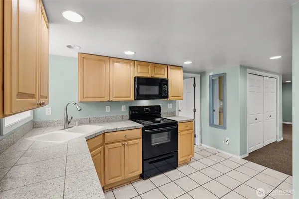 a kitchen with stainless steel appliances granite countertop a stove a sink and a refrigerator
