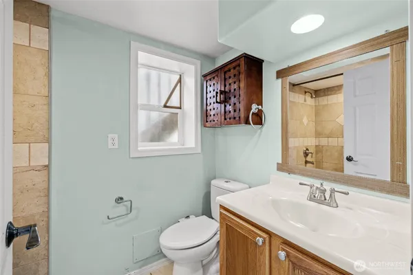 a bathroom with a toilet a sink and mirror