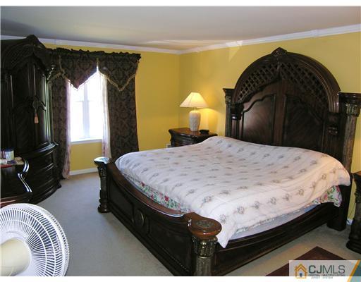 46 Lexington Road Monmouth Junction, NJ 08852 - Photo 7 of 10 a bed sitting in a bedroom next to a window and a chandelier
