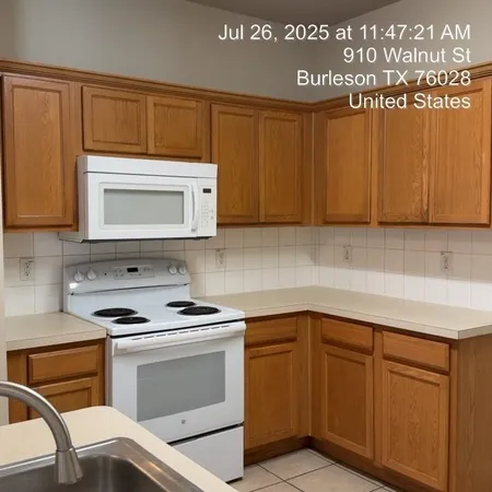 a kitchen with granite countertop cabinets stainless steel appliances and wooden cabinets
