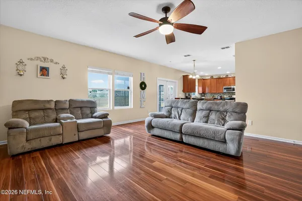 a living room with furniture and a wooden floor
