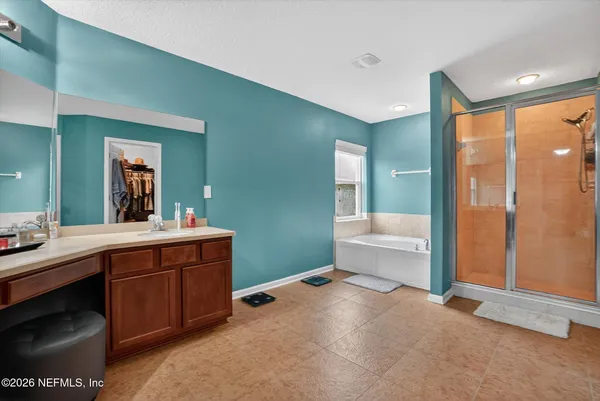 a spacious bathroom with a tub sink and mirror